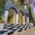 Balboa Park Hotel in San Diego exterior with arched entry, checkered steps, and tree-lined sidewalk