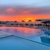 Zorbas Beach Village Hotel in Stavros: sunset view over pool with sea and umbrellas