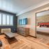 Hotel Lexen Newhall in Newhall room with sofa, coffee table, wall-mounted TV and bedroom doorway