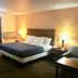 Passport Inn and Suites - Middletown guest room with king bed, nightstands and lamps