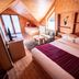 Natyral Razma Resort in Razem: wooden chalet room with two beds, sofa, TV and mountain window views