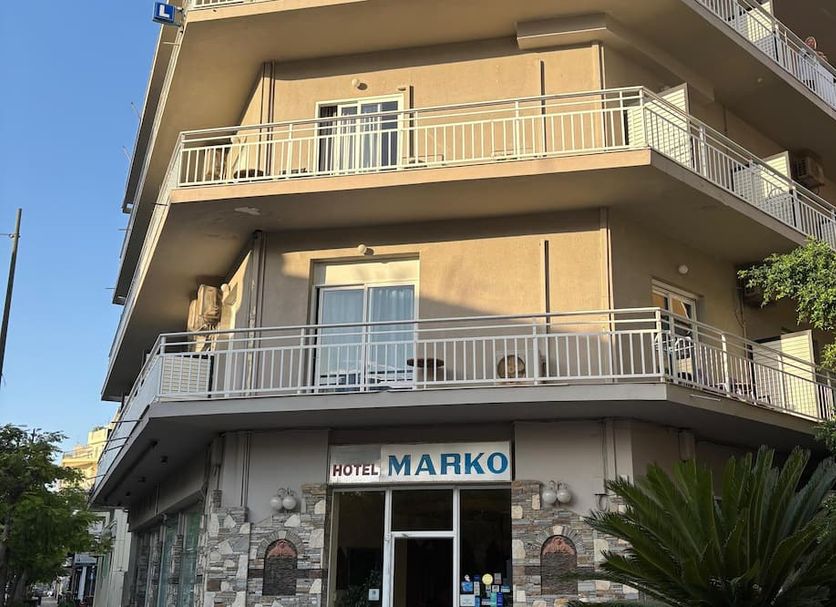 Hotel Marko in Loutraki, beige hotel exterior with balconies and entrance sign