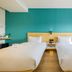 Pace Hotel Suzhou Renmin Road guest room with two beds and teal accent wall in Suzhou