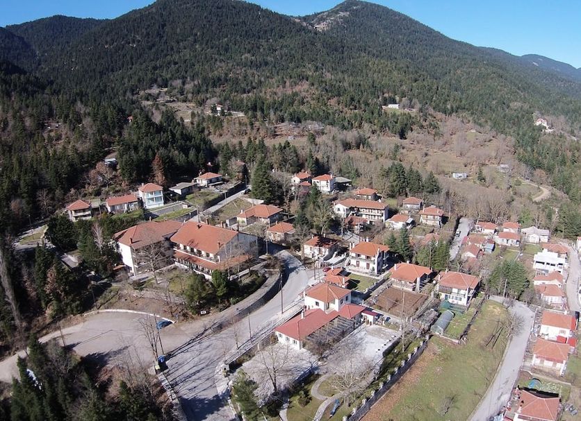 Country Club Hotel & Suites in Mikro Chorio with mountain views over the village and forested hills.