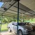 Kinabalu Poring Vacation Lodge in Kundasang carport with parked pickup trucks and a covered outdoor table