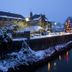 Exmoor White Horse Inn in Minehead beside a snowy riverside at dusk with festive lights