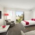 Quest Sanctuary Lakes in Melbourne guest room with bed, desk, sofa, and balcony garden view