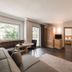Klein Fein Hotel Anderlahn in Parcines: spacious suite with sofa, table, wood floors and window view