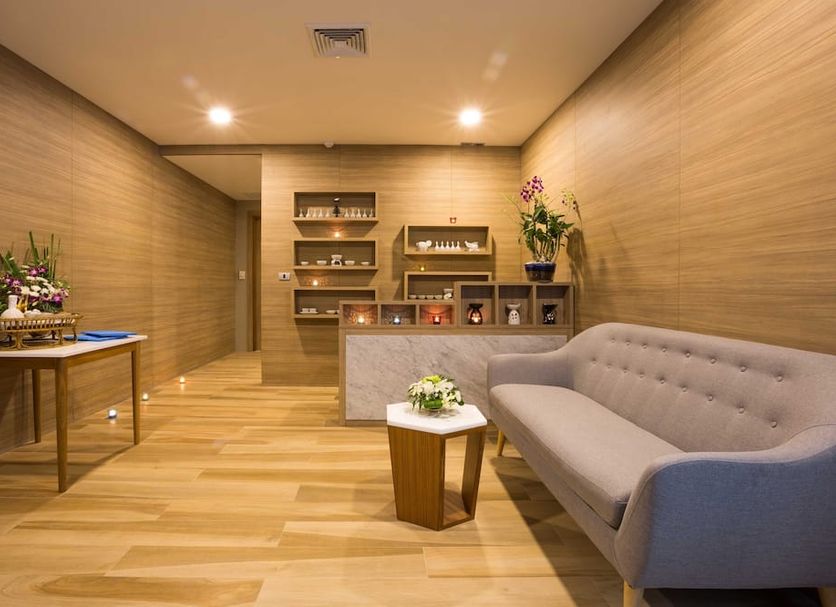 Bluesotel Krabi Aonang Beach lobby lounge with sofa, flowers and wood shelving in Ao Nang