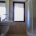 Flora Daisy Apartment in Borovets bathroom with shower stall, sink and frosted window