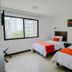 Hotel Pinares Plaza in Pereira guest room with two beds and a large window