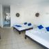 Hotel Paraiso Kora in San Blas room with two beds, desk, tiled floor, and wall decor