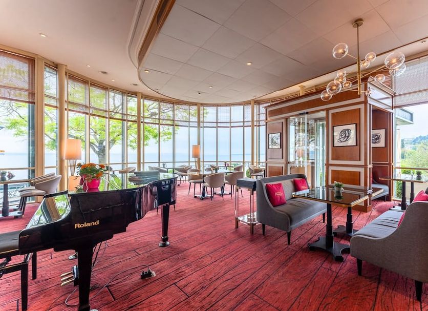 Beau Rivage Hotel in Neuchâtel lounge with grand piano and lake views through floor-to-ceiling windows