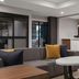 Homewood Suites by Hilton Fresno lobby with gray sofa, round table, and marble front desk