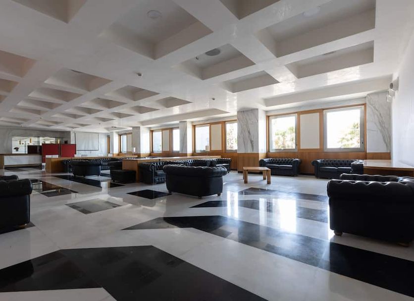 Grand Hotel Salerno lobby with black leather seating, marble floor, and large windows in Salerno