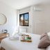 Biancaleuca Rooms & Suite in Leuca guest room with bed, window, wall AC, and small wicker table
