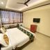 Hotel Chevron International, Ludhiāna guest room with double bed, TV, and window seating area