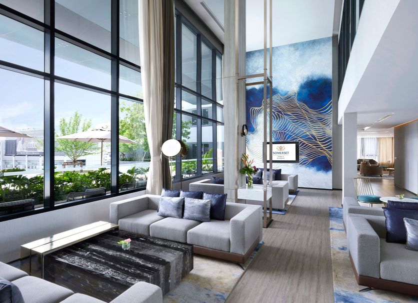 Somerset Rama 9 Bangkok lounge with floor-to-ceiling windows and blue wall art in Bangkok