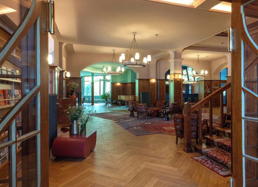 Boutique Hotel Engadinerhof in Pontresina lobby with wood staircase and arched lounge seating