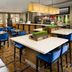 Courtyard by Marriott San Antonio Lackland dining area with tables, blue chairs, and bar seating