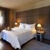 Hotel da Oliveira in Guimarães guest room with double bed, bedside lamps, desk and window with curtains.