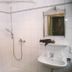 Hotel Vier Jahreszeiten, Volkach bathroom with tiled shower, sink, mirror, and wall-mounted showerhead