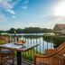 Tisza Balneum Hotel in Holló patio table and wicker chairs beside a lake at sunset