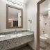 Bathroom at Red Roof Inn Birmingham South in Birmingham with granite vanity, mirror, toilet and shower-tub combo