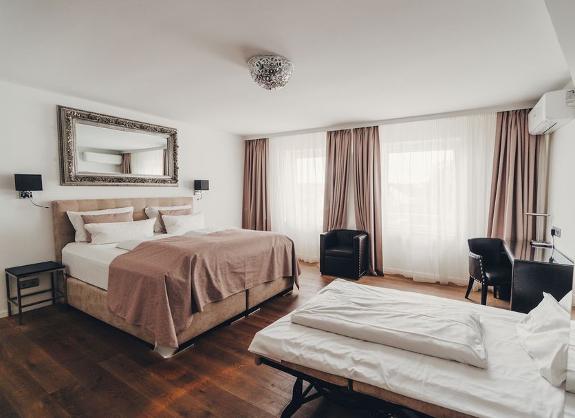 Boutique Hotel Berial Düsseldorf guest room with bed, sofa bed, desk and tall windows