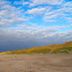 Beach and dunes at Hotel Het Oude Raadhuis in Castricum under a cloudy blue sky