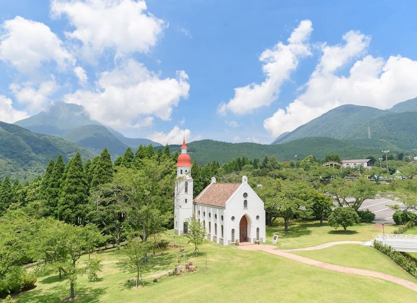 Kijima Kogen Hotel in Beppu, white chapel with red roof in green gardens and mountain views