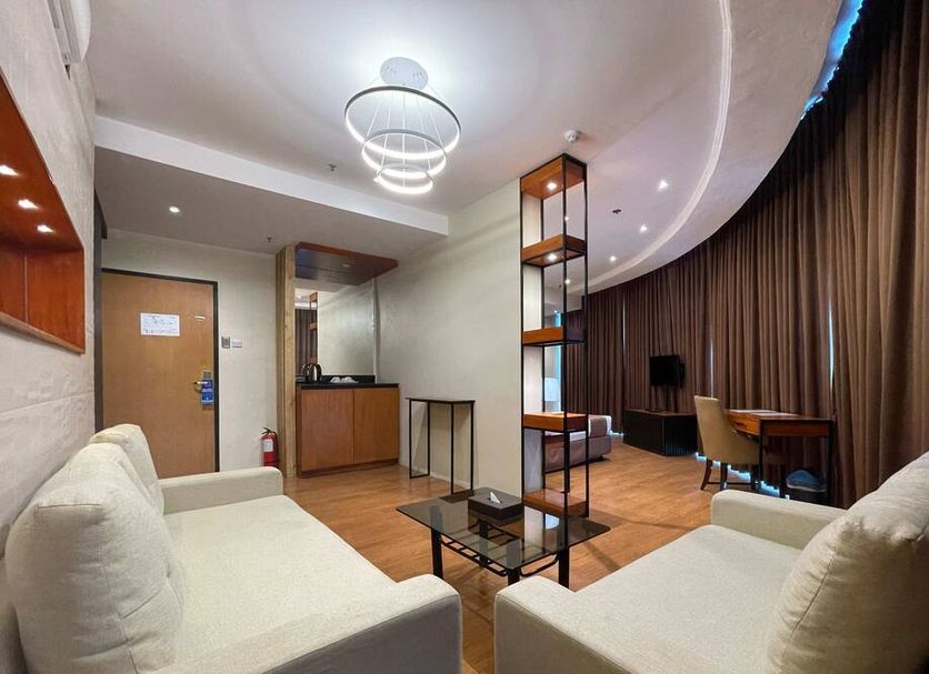 Golden Peak Hotel & Suites powered by Cocotel in Cebu City, modern suite with seating area and curved window curtains