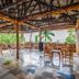 Hotel Royal Nest Entebbe open-air restaurant with wooden tables and tropical garden views