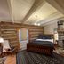 Silver Lake Bed And Breakfast in Harrisonburg: rustic bedroom with stone fireplace and wood plank walls