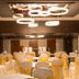 Hotel Le Temps Fort in Tiruchirappalli banquet hall with round tables and white chair covers