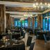 AC Hotel Fort Worth Downtown dining room with dark tables, chandeliers, and large windows overlooking Fort Worth