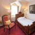 Romantik Parkhotel Wasserburg Anholt room in Isselburg with a single bed, armchair, desk, TV and flowers
