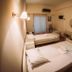 Hotel King Pyrros room in Ioánnina with two single beds, wall lamp, mirror and window