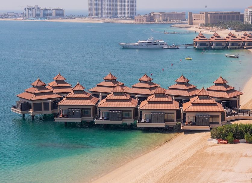 Royal Central Hotel The Palm in Dubai with overwater villas and a sandy beach by turquoise sea