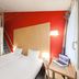 B&B HOTEL Dieppe room with loft bed, two single beds, red accent wall and desk in Saint-Aubin-sur-Scie