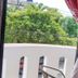 OYO Hotel Arena Surf, Puerto Escondido balcony view with trees and street beyond white railing