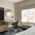 La Quinta Inn & Suites by Wyndham Austin Southwest room with TV, desk, chair and large window in Austin