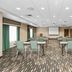 Hampton Inn Pittsburgh-Bridgeville meeting room with tables, chairs, and projector screen in Bridgeville