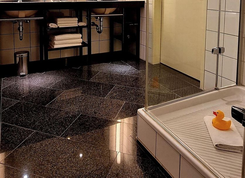 Mintrops Stadt Hotel Margarethenhöhe in Essen bathroom with double sink vanity and glass shower enclosure