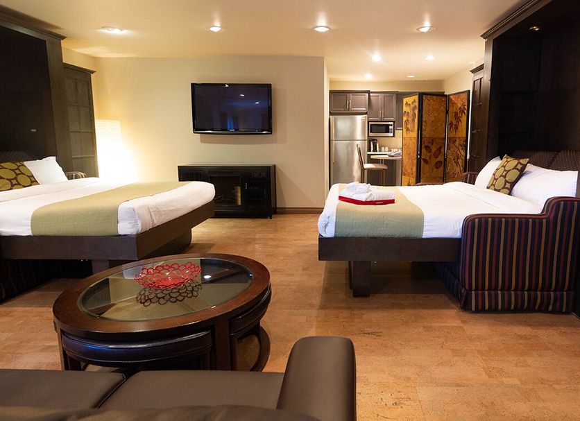 Hôtel Énergie Shawinigan guest room with two beds, TV, fireplace and kitchenette in Shawinigan