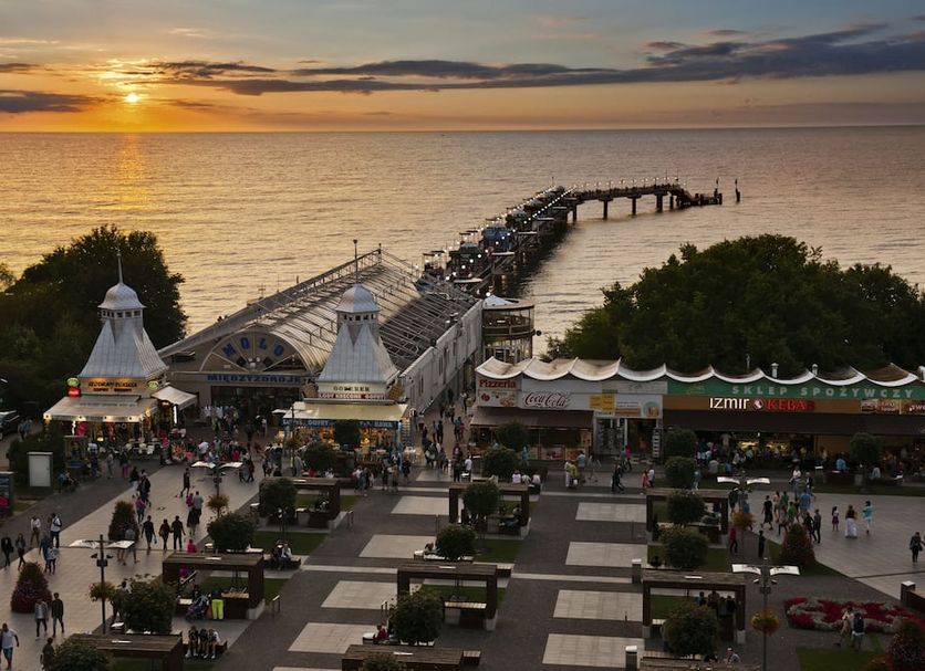 Hotel Aurora Family & Spa in Międzyzdroje overlooking a sunset beach and long pier