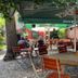 Homeplanet Hostel Leipzig outdoor courtyard seating with tables, chairs, and green umbrellas