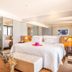 Pestana Rio Atlântica suite with ocean view, king bed, vanity, and lounge chair in Rio de Janeiro