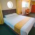 Hotel La Joya in Huaraz room with double bed, chair, sofa, window and round wall mirror