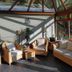 Bryn Melyn Apartments in Barmouth sunroom lounge with wicker seating and a glass roof